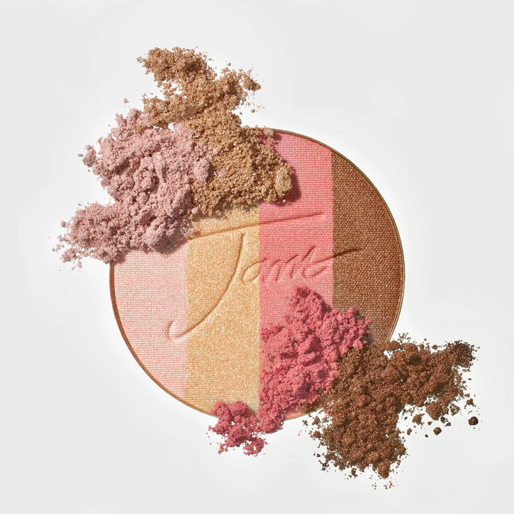 PureBronze Shimmer Bronzer refill in First Light, shown open with the pressed powder pan and soft crushed pigment scattered across the surface in champagne pink, gold and bronze shimmer tones.