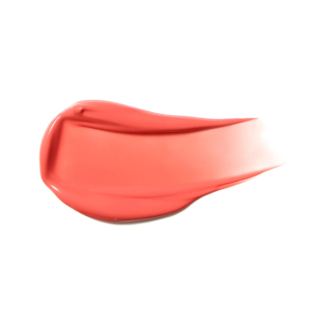 Swoosh of coral-colored liquid blush product on a white background
