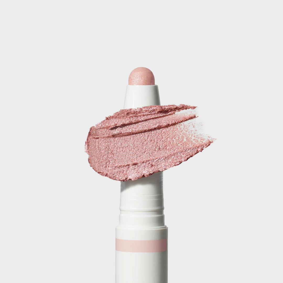 Jane Iredale® ColorLuxe Eye Shadow Stick in Prima, shown in a white twist-up tube with the cream shadow bullet extended and a shimmering light pink pearl swipe across the front