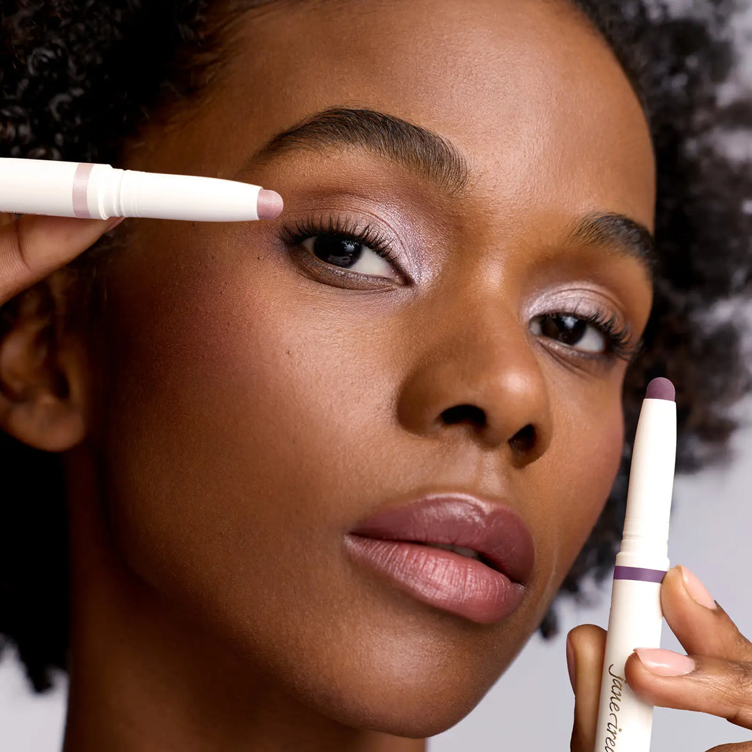 Close-up of a model applying makeup ColorLuxe Eye Shadow Sticks in shades Prima and Provence near their eye.
