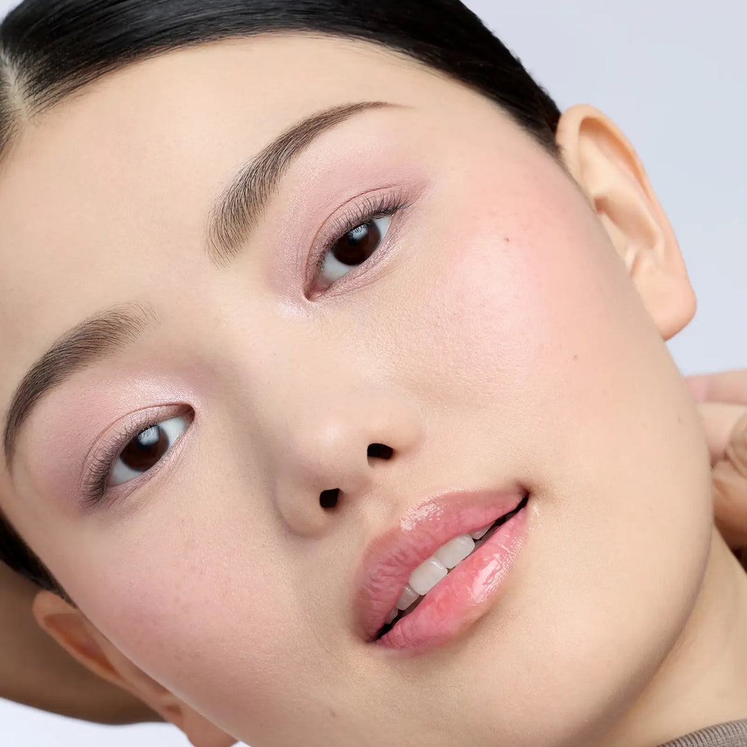 Close-up of a person's face with a neutral background showing Cameo and Prima ColorLuxe Eye Shadow Sticks applied to the eyelids