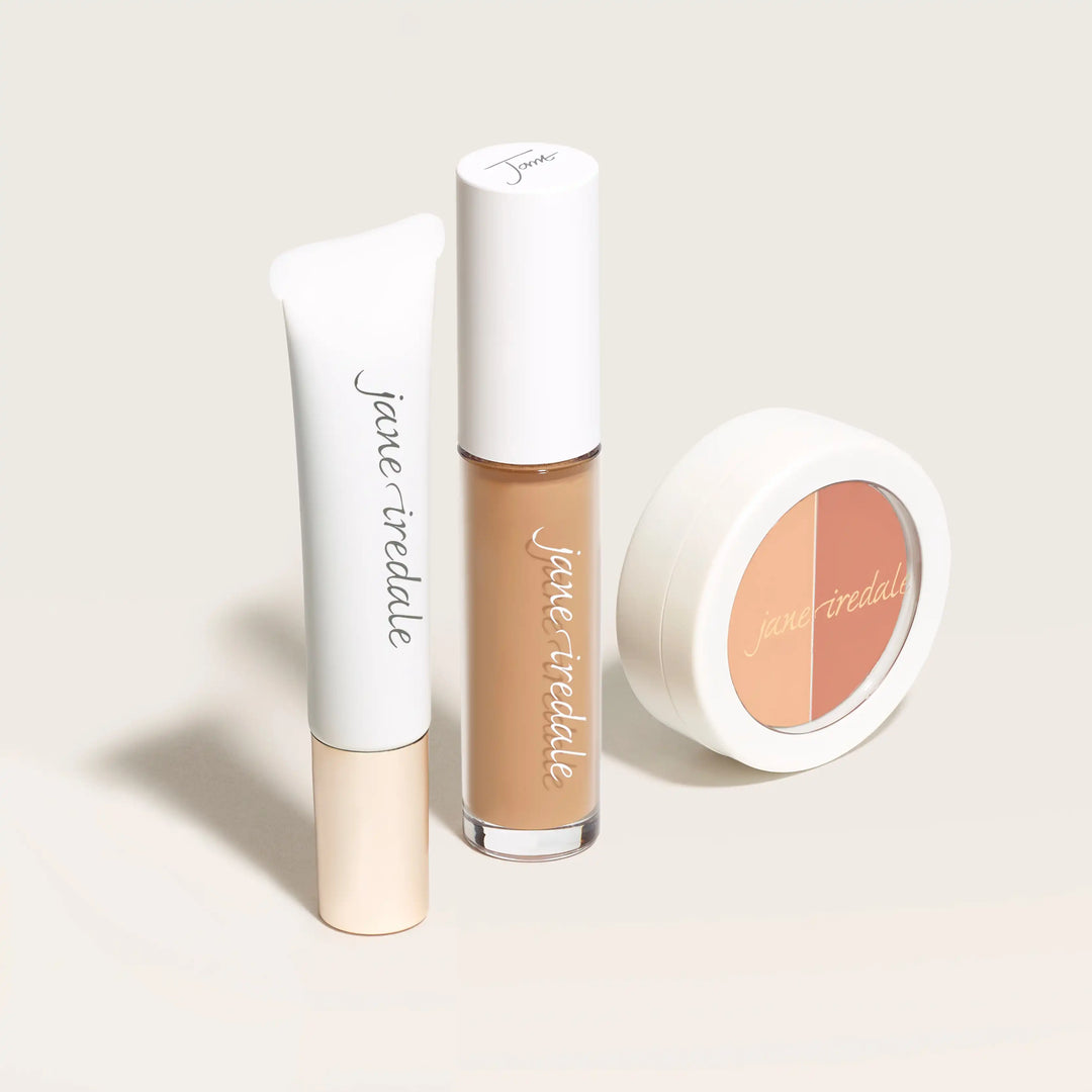 Three Jane Iredale concealer makeup products on a light background