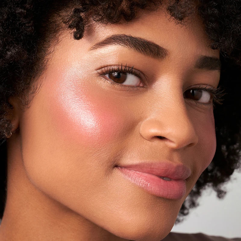 Close up of model wearing a pink blush with a radiant glow